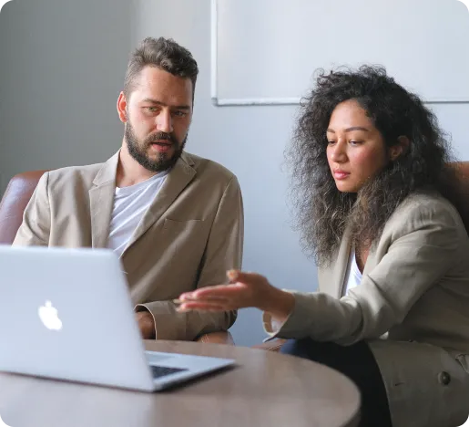 a man and woman looking at a laptop