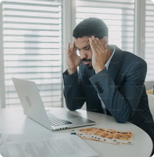 a frustrated man sitting at a table because of low quality raster image